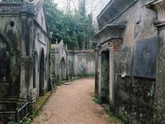 an old cemetery with stone buildings and trees in the background