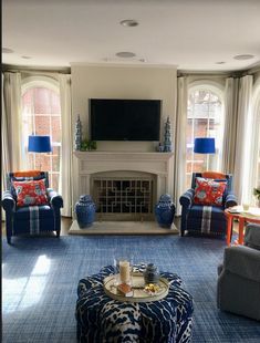 a living room filled with furniture and a flat screen tv mounted above a fire place