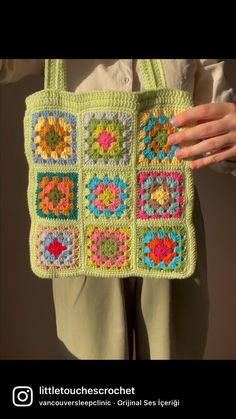 a crocheted bag is being held by someone