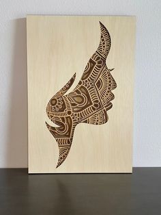 a wooden block with an animal's head drawn in intricately designed lines on it