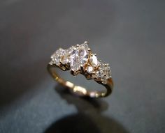 a three stone diamond ring sitting on top of a table