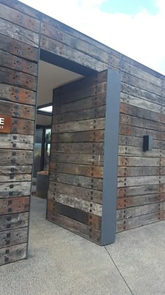 an entrance to a building made out of wooden planks