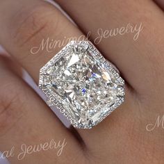 a woman's engagement ring with a cushion cut diamond in the center and pave set shoulders