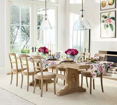 a dining room table and chairs with flowers on the table cloths in front of them