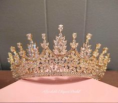 a tiara is shown on top of a pink box