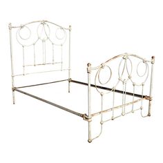 an old white metal bed frame with curved headboard and foot board