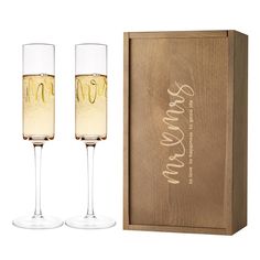 two champagne flutes in front of a wooden box