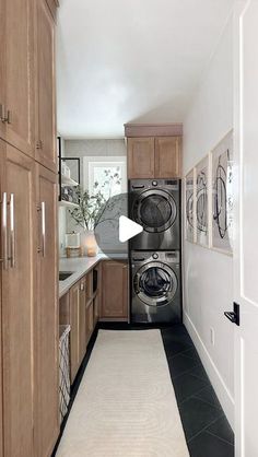 a very long narrow kitchen with wood cabinets and washer and dryer in it