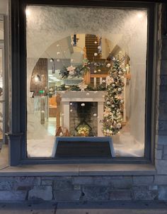 a store window with a fireplace and christmas decorations