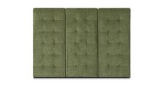 the back side of an upholstered headboard with buttons on it, in green fabric