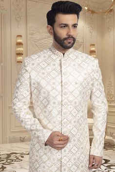 This sherwani is perfect for grooms and guests alike, featuring intricate thread and sequin work. Look dashing and stand out at any event. Add a touch of elegance to your ensemble with our R14-S55 mens sherwani. Designer Off-white Bandhgala For Eid, Designer Off-white Bandhgala With Resham Embroidery, Fitted Off White Sherwani With Chikankari Embroidery, Fitted Off-white Sherwani With Chikankari Embroidery, White Resham Embroidery Nehru Jacket, White Resham Embroidered Fitted Nehru Jacket, Bollywood Sherwani With Intricate Embroidery For Groom, Fitted Chikankari Embroidery Sherwani For Groom, Groom's White Sherwani With Dabka Work