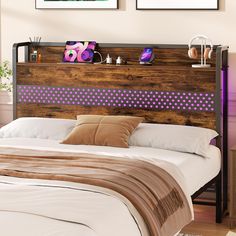 a bed with two pictures on the wall above it, and a purple polka dot headboard