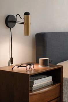 a bedroom with a bed, nightstand and eyeglasses on top of the night stand