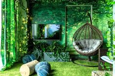 a room with green walls and grass on the floor, hanging chairs in front of a window