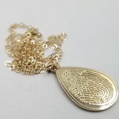 "All orders over $700 will receive a FREE sterling silver memorial fingerprint oval pendant mounted on an 18 inch sterling silver necklace. These pendants serve as a wonderful memorials, beautifully shaped in a meaningful teardrop design. his, the highest quality 10k solid gold, will remain maintenance free nearly to the level of 14k. You will have the piece of mind knowing the quality of the material and workmanship put into this pendant is at the highest quality level achievable. Every piece m Teardrop 14k Stamped Jewelry As Gift, Gold Teardrop Jewelry Stamped 14k, 14k Stamped Teardrop Jewelry Gift, Teardrop Shaped 14k Stamped Jewelry Gift, Gold Teardrop Keepsake Jewelry, Teardrop Engraved Jewelry Gift, Engraved White Gold Teardrop Jewelry, Keepsake Gold Stamped Jewelry, Engraved Teardrop Jewelry For Gift