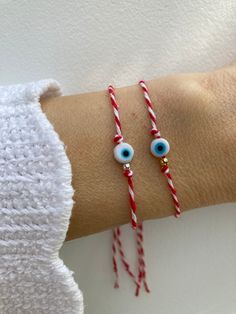 "Keep yourself protected with this Greek March/evil eye bracelet. It is a tradition dating back to antiquity and is used to protect the wearer from sunburn and evil.  D E T A I L S  *It features a small glass evil eye charm on the traditional red and white cotton cord that is used in a Greek March bracelet - \"martaki\" *Choose between a gold filled or sterling silver bead. *Bracelet is adjustable. Just move the slider bead holding the cords up or down. P A C K A G I N G: All our products are gi White Round Beaded Bracelet For Good Luck, Spiritual White Bracelets For Good Luck, Evil Eye Bracelet For Friendship, White Evil Eye Bracelets As Gift, White Spiritual Bracelet For Good Luck, Spiritual White Bracelet For Good Luck, Symbolic White Bracelets For Friendship, White Symbolic Friendship Bracelets, Spiritual Evil Eye Bracelets For Friendship