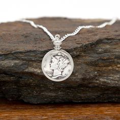 Introducing our exquisite Custom Date Dime Necklace, a perfect treasure to commemorate your loved one's special moments! Whether it's a birthday, anniversary, or any other occasion, this unique piece makes an extraordinary gift that will be cherished forever. Features and Details: - Adorned with an 18 inch sterling silver-plated curb chain, this necklace exudes elegance and is designed to be comfortably worn every day. - The dime is bezel mounted, ensuring lasting protection while enhancing the beauty of the coin. - Each necklace is exclusively made to order, allowing you to create a truly personalized keepsake. Select the memorable year of any significant event. Capturing those precious memories has never been easier! We truly understand the importance of unforgettable moments. This Custo Nickel-free Heirloom Jewelry For Anniversary, Heirloom Nickel-free Jewelry For Anniversary, Silver Medallion Necklace For Anniversary Gift, Classic Charm Necklace For Anniversary, Anniversary Coin Pendant Jewelry, Anniversary Gift Coin Pendant Jewelry, Classic Engraved Jewelry For Birthday Gift, Classic Jewelry For Birthday Gift, Classic White Gold Charm Necklaces For Anniversary