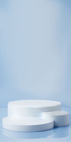 two white circular tables sitting on top of a blue surface