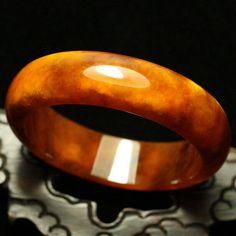 59mm Golden Yellow and White Clouds Hand-carved Natural Jade Bangle #A3 weight: 76.5g, 421.5 Ct Jade NameNatural Jade Item SizeInner diameter: 58 mm Width:17.6mm Thickness: 7.1 mm This unique bangle has lots of internal feature with clouds, silk streaks and wen. Inviting autumn color with this golden orange tawny with white flowers. This is a gorgeous and high quality jadeite bangle. Luxury Round Amber Jewelry, Luxury Carved Jewelry For Formal Occasions, Brown Bangle Jewelry For Formal Occasions, Brown Bangle For Formal Occasions, Elegant Brown Bangle For Formal Occasions, Elegant Formal Brown Bangle, Luxury Collectible Round Bangle, Handmade Luxury Bangle For Formal Occasions, Luxury Handmade Bangle For Formal Occasions