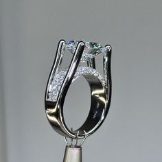 a diamond ring on top of a silver stand