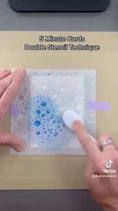 two hands are using glue to make a card with dots and small technique on it