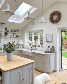 a kitchen with an island and skylight in the ceiling, along with white cabinets