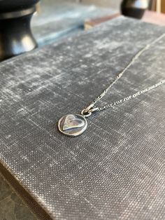 "This nickel-sized solid sterling silver heart pendant is a great way to bring you or a loved-one a virtual hug. The perfect gift. May request up to 3 initials stamped on the back (request in notes). Cast from recycled sterling silver scrap metal. Available in 16\" & 18\" length (make your selection at check out) on an oxidized (antiqued) flat figaro style chain." Stamped Sterling Silver Heart Pendant Necklace, Silver Necklace With Initial Pendant And Heart Charm, Sterling Silver Heart Necklace With Round Pendant, Silver Heart Charm Necklace For Mother's Day, Silver Hand Stamped Heart Necklace For Anniversary, Silver Stamped Necklaces For Anniversary Gift, Silver Heart Necklace With Round Pendant For Keepsake, Silver Heart Necklace With Round Pendant For Mother's Day, Hypoallergenic Sterling Silver Heart Pendant Necklace