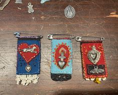 three key fobs hanging from hooks on a wooden table next to other items