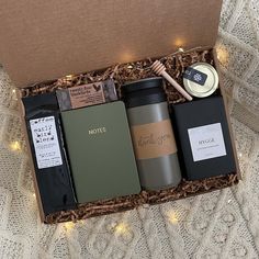 an open box containing two coffees, a tea cup and a honeybee wax