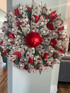 a red and white christmas wreath hanging on the wall