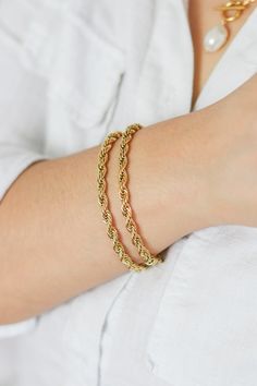 Our Adela Twist Bracelet is a beautiful rope chain that is a versatile piece that can be worn on it's own or paired with other jewelry for a layered look. This bracelet adds the perfect touch of chic and luxury. To complete the look pair it with our Elisa Layered Necklace. THE DETAILS Color: PVD 18K Gold PlatedMaterial: Stainless SteelSize: 5mm Thick x 17cm With 5cm Extender READ HOW TO CARE FOR JEWELRY HERE Gold Plated Bracelets