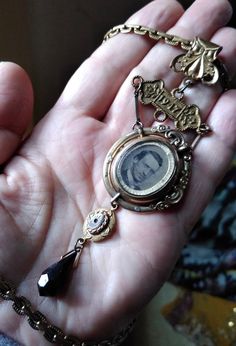 An assemblage of a brass book chain necklace from the 1930s suspending a gilded florid Victorian watch chain clasp element holding a vintage brass link from a St. John's Hospital belt link from England dated 1947, which in turn hold an old gilded Victorian swivel brooch. The brooch is missing the pin in the back plus scroll elements on the front. It is also missing the glass and photo that was on the back of the brooch. I've added a faceted jet cabochon from the 1920s. Terminates in a black glas Vintage Brass Necklaces For Formal Occasions, Vintage Brass Necklace For Formal Occasions, Victorian Brass Necklace For Vintage Events, Vintage Brass Necklaces For Vintage Events, Vintage Brass Necklace For Vintage Events, Antique Gold Necklace For Vintage Events, Victorian Antique Gold Necklace For Vintage Collection, Vintage Brass Jewelry For Vintage Events, Vintage Charm Brass Necklaces For Vintage Events