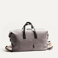 a gray duffel bag sitting on top of a white floor