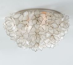 a close up of a light fixture with white flowers on it's center piece