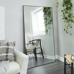 a living room filled with furniture and a large mirror