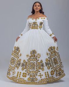 Step into the world of Ethiopian fashion with the mesmerizing beauty of the Habesha Kemis. This traditional attire, adorned with intricate embroidery and crafted from the finest Menen fabric, is a true masterpiece that embodies the rich cultural heritage of Ethiopia. Immerse yourself in the breathtaking artistry of the Habesha Kemis, where every stitch tells a story and every thread weaves a connection to the past. The full embroidery adorning this garment showcases the unparalleled skills of Et Anarkali Floor-length Dress With Embroidered Neckline, Floor-length Dresses With Embroidered Neckline For Festive Occasions, Festive Floor-length Dresses With Embroidered Neckline, Festive White Dress With Gold Embroidery, Festival Anarkali Dress With Embroidered Neckline, Anarkali Dress With Embroidered Neckline For Festivals, Anarkali Style Long Sleeve Maxi Dress For Traditional Ceremonies, Bohemian Fitted Dress With Pallu, Fitted Bohemian Dresses With Pallu