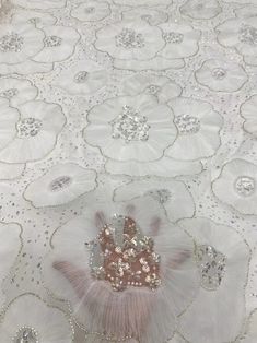 a white table cloth with silver sequins and a pink crown on the center