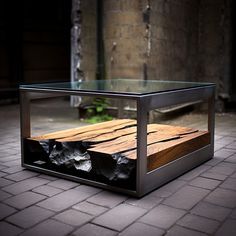 a glass and metal coffee table sitting on top of a brick floor