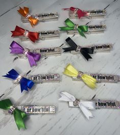 six different colored bows with the words bow it down on them in silver, black, red, and green