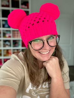 a woman wearing glasses and a pink knitted mouse hat