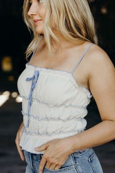 Head to the west(coast) in style with The Juliana Top. This cropped tank top features a charming cream color and playful ruffle details. The front bow adds a touch of cute cowgirl charm, perfect for a sunny summer day. Keasha is wearing size small paired with The Stacie Shorts Spring Sleeveless Tank Top For Picnic, Cream Cropped Top For Day Out, Cream Cropped Crop Top For Spring, Feminine Summer Tank Top With Ruffle Hem, Feminine Summer Crop Top For Day Out, Sleeveless Ruffled Tops For Picnic, Spring Tank Top With Tie Straps, Summer Tank Top With Tie Straps For Spring, Feminine Ruffled Crop Top For Vacation