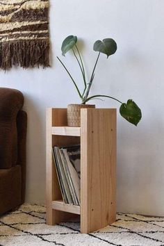 a plant in a wooden vase on top of a book shelf next to a chair