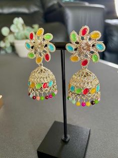 Elevate your style with our stunning duo pack featuring two unique designs.  ** Multistone Jhumkas** bring a traditional flair with vibrant stones, perfect for festive occasions or cultural outfits.   ** Gold Plated Red Stone Earrings these pieces add a bold pop of color and sophistication to any look.  Multicolor Jhumkas Length - 5.5 Cm ; Width - 2.3 Cm Redstone Earrings Length - 3.8 Cm ; W - 1.8 Cm Multicolor Metal Earrings For Festivals, Multicolor Metal Earrings For Party, Fusion Style Multicolor Metal Earrings, Multicolor Metal Chandbali Earrings, Multicolor Chandbali Jhumkas As Gift, Multicolor Chandbali Jhumkas For Gift, Multicolor Fusion Jhumkas For Diwali, Multicolor Jhumkas For Diwali, Fusion Style Multicolor Jhumkas For Diwali