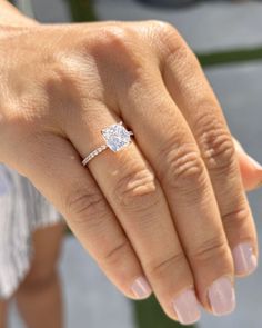 a close up of a person's hand with a diamond ring on their finger