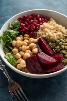 a bowl with beets, carrots, beans and other food items in it