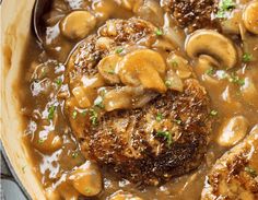 meat and mushroom stew in a skillet with a ladle on the side, ready to be eaten