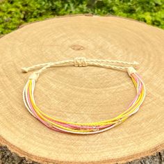 Stylish handmade friendship bracelet, made from loosely braided waxed cord threads in vanilla, pink, white and yellow colors, with decoration small silver lined seed beads. The bracelet fastens with a sliding knot so you can adjust the size to fit perfectly. Minimum diameter when it's closed is 15-16cm. and the fastening threads allows it to be opened to around 28-30cm. The waxed cord thickness is 1mm. If you need specific size please let us know, custom orders are welcome, feel free to contact Surf Bracelet, Handmade Friendship Bracelets, Silver Line, Sliding Knot, Macrame Jewelry, Pink And Yellow, Handmade Bracelet, Braided Bracelets, Friendship Bracelet