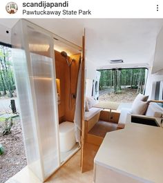 the inside of a camper with its door open to reveal a bathroom and living area