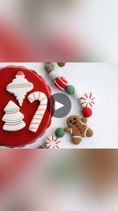 a red plate topped with cookies and candy canes on top of a white table