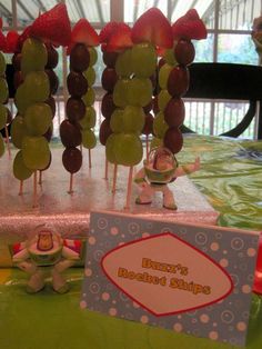 a table topped with lots of fruit on sticks